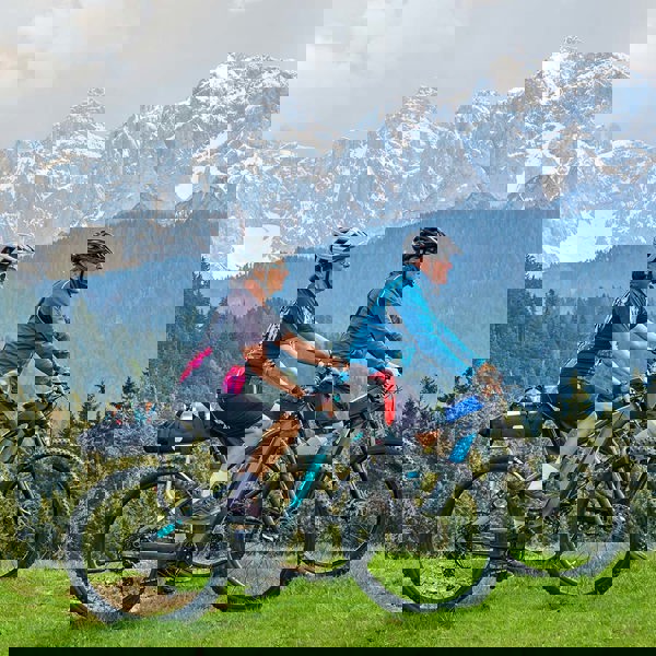 A couple riding E-bikes together in the mountains
