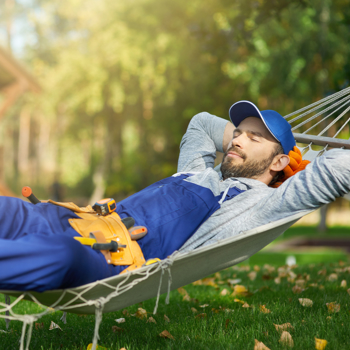Man with a tool belt relaxing on a hammock.