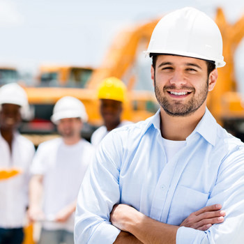 Some workers in bright hardhats at a construction site.