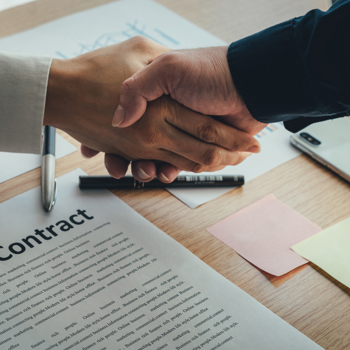 Two hands shaking over a contract