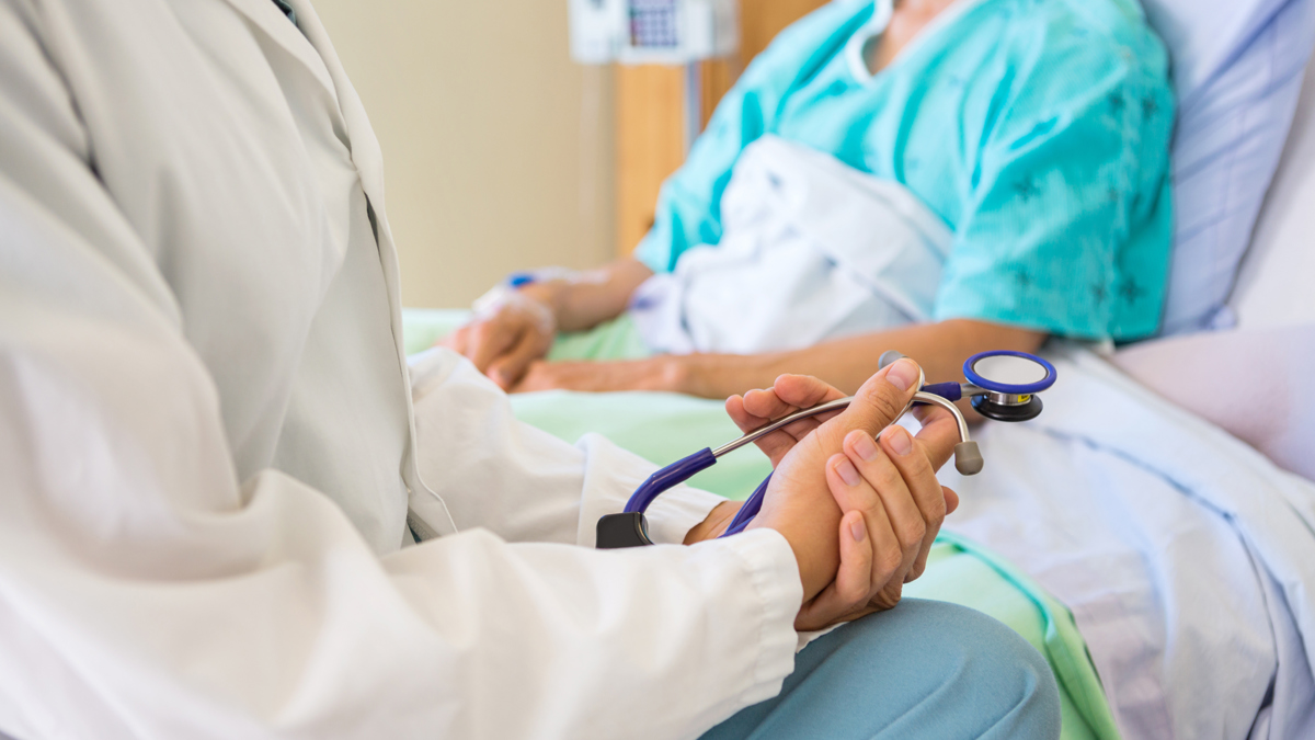 A doctor at the bedside of a patient.
