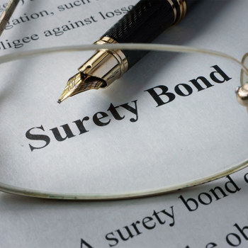 A fancy pen laying on a document titled 'Surety Bond'