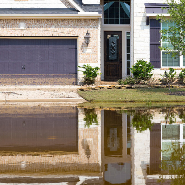 A home with water piling up on the front lawn
