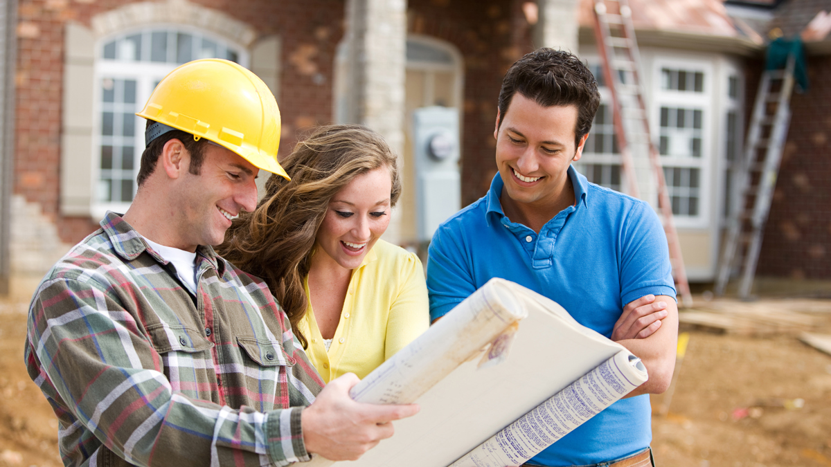 A Builder looking over plans with an excited couple.