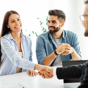 A couple meeting with an insurance agent in a brightly lit office.