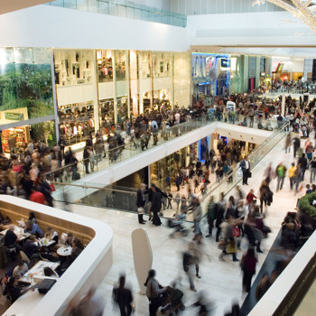 Blurry throngs of shoppers in an indoor mall