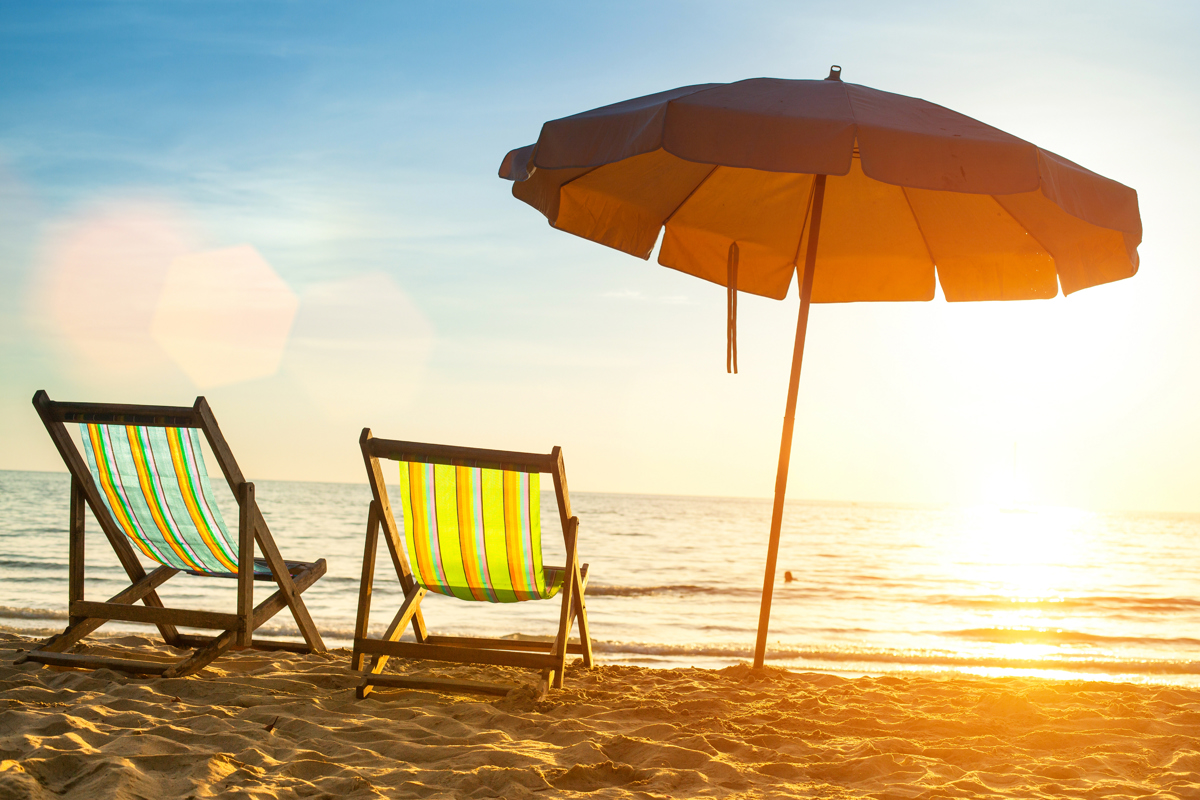 Two colorful beach chairs on a tropical beach.