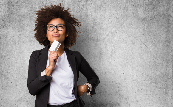 A woman with a credit card pondering finances