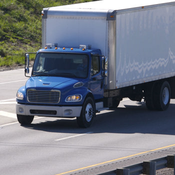 A blue semi truck traveling on a highway