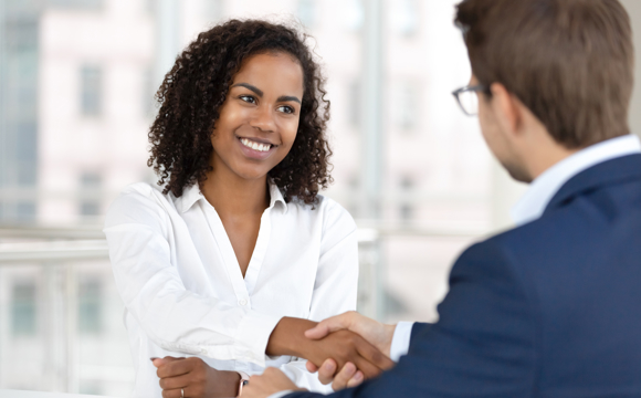 A customer smiling as she works with a credit union manager.