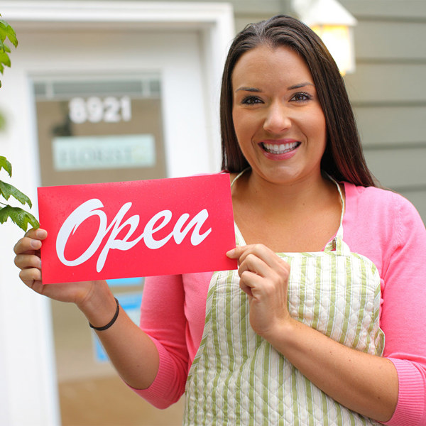 A small business owner outside her shop, smiling