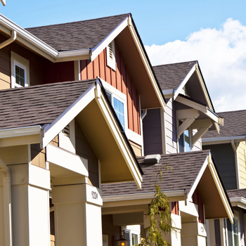 A row of colorful townhomes under a blue sky