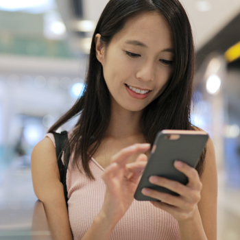 Woman walking while using her phone.