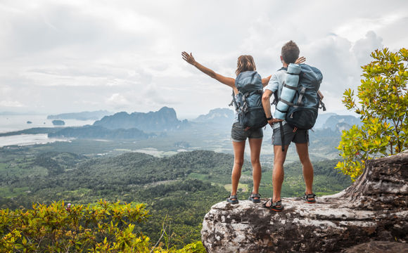 A backpacking couple looking over an expansive mountain vista.