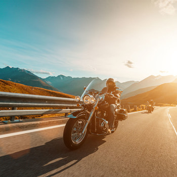 Two people riding their motorcycles through the canyon