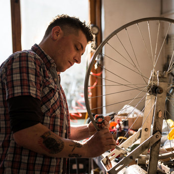 An employee repairing a bicycle in a small bike shop
