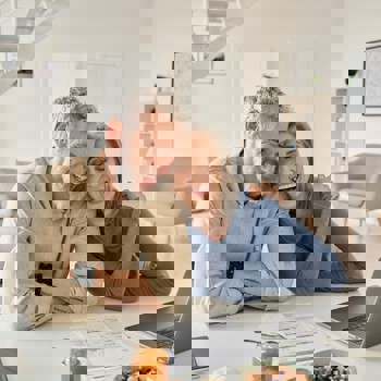 An older couple looking at a laptop.